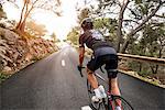 Woman cycling on country road