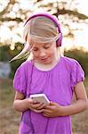 Sweden, Gotland, Faro, Girl (8-9) listening to music from smart phone