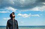 Sweden, Oland, Portrait of man in hooded shirt looking at sky