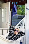 Sweden, Varmdo, Mature woman relaxing in hammock