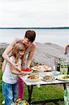 Sweden, Uppland, Roslagen, Woman preparing picnic table at seaside