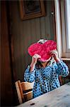 Sweden, Girl (2-3) holding paper heart in front of face