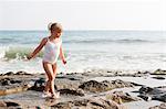 Turkey, Alanya, Blonde girl (4-5) walking on rock beach