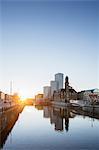 Sweden, Skane, Malmo, Waterfront cityscape at sunset