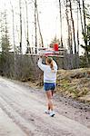 Sweden, Uppland, Lanna, Girl (12-13) carrying plane over head