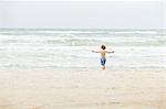 Denmark, Vendsyssel, Jutland, Lokken, Boy (8-9) standing on beach