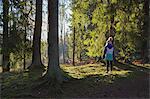 Sweden, Smaland, Anderstorp, Girl (10-11) standing in forest, rear view