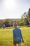 Sweden, Narke, Garphyttan, Rear view of blonde woman on meadow