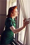 Sweden, Woman looking trough window