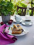 Sweden, Plum tart on plate, coffee cup and milk on table