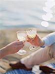 Sweden, Bohuslan, Fjallbacka, Couple toasting with glasses of champagne on sandy beach
