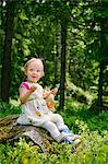 Finland, Paijat-Hame, Girl (2-3) playing with doll in forest