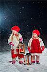 Finland, Sisters (12-17 months, 2-3) standing in backyard at night