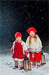 Finland, Portrait of sisters (12-17 months, 2-3) standing in backyard at night