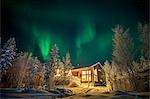 Finland, Lapland, Kittila, Levi, Aurora borealis over cottage