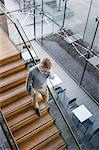 Finland, Young businessman walking downstairs and talking on phone