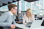 Finland, Colleagues sitting at desk and talking