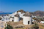 A typical Greek village perched on a rock with white and blue houses and quaint windmills, Ios, Cyclades, Greek Islands, Greece, Europe