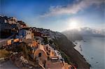 Sunbeam through the clouds over the Aegean Sea seen from the typical village of Oia, Santorini, Cyclades, Greek Islands, Greece, Europe