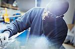 Focused steel worker examining part in steel factory