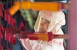 Worker painting steel red in steel factory