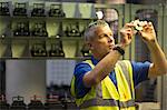 Worker examining part in steel factory