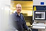 Portrait confident worker at control panel in steel factory