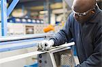 Worker sanding steel in steel factory