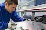 Worker operating laser cutter in steel factory