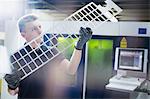 Worker examining piece in steel factory