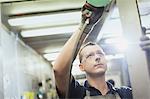 Worker sanding steel in steel factory