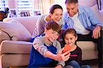 Family taking selfie with camera phone in living room