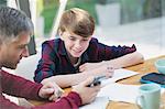 Father with calculator helping son with math homework