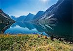 Friends relaxing at sunny tranquil mountain lakeside, Norway