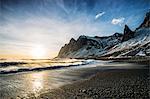 Sun setting over tranquil beach and snowy mountain, Iceland