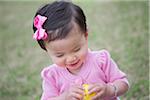 Toddler Girl Smiling while she Opens an Easter Egg