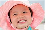 Close-up Portrait of Toddler Girl wearing Sunhat and Smiling at Beach, Destin, Florida, USA