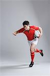 Portrait of Japanese rugby player running with ball