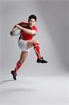 Portrait of Japanese rugby player running with ball