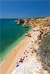 Tourists on sandy beach Praia da Marinha surrounded by turquoise ocean, Caramujeira, Lagoa Municipality, Algarve, Portugal, Europe
