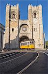 The yellow tram number 28 close to the ancient Cathedral (Se), Alfama district, Lisbon, Portugal, Europe