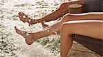 Young couple splashing bare feet in lake