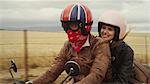 Young couple riding motorcycle in rural countryside