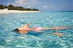 Serene woman floating in tropical ocean