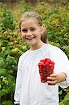 Sweden, Stockholm, Girl (8-9) with cup of raspberries