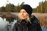 Sweden, Ostergotland, Lotorp, Mature woman looking away, forest in background