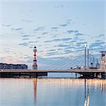 Sweden, Skane, Malmo, Illuminated suspension bridge and lighthouse