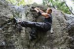 Sweden, Sodermanland, Tyreso, Sportsman doing bouldering in forest