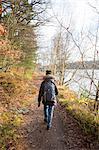Sweden, Vastergotland, Lerum, Lake Aspen, Woman on footpath by lake