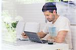 Sweden, Mid adult man using laptop